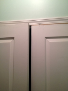 A photo of laundry room doors that are slightly open due to a problem with their door balls stops. 